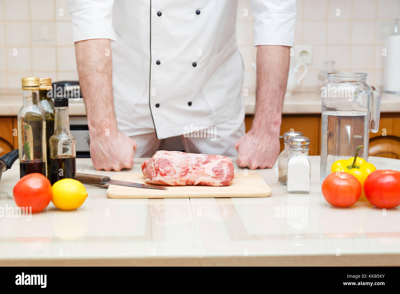 Male chef de la préparation pour la cuisson du porc filet à une cuisine de restaurant. Banque D'Images