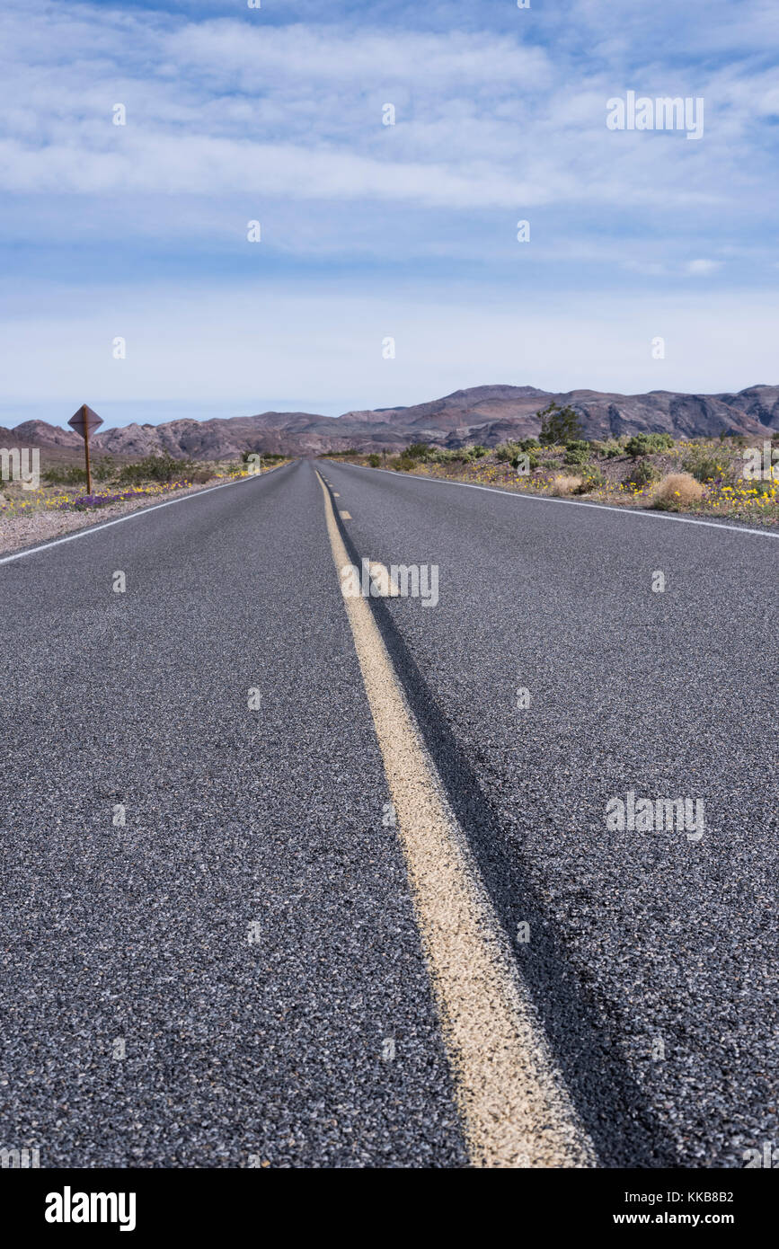 Route déserte dans le désert avec des montagnes en arrière-plan Banque D'Images