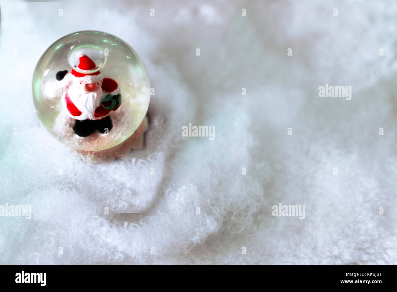 Crystal snow ball avec le père Noël à l'intérieur de la neige blanche fond flou avec l'espace pour le texte. Noël ou Nouvel An, modèle de carte de vœux. Banque D'Images