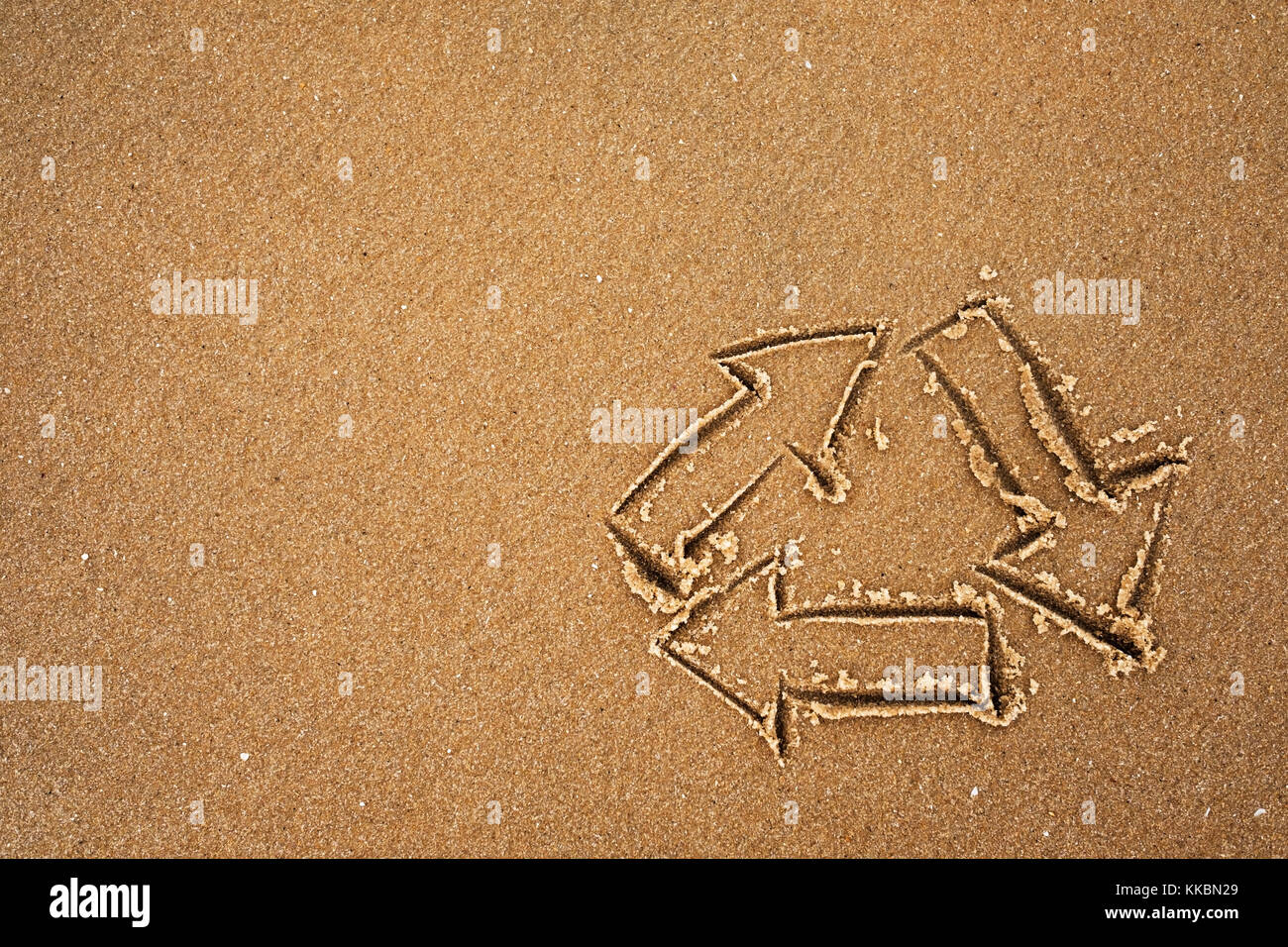 Logo de recyclage s'appuyant sur le sable au bord de mer. Banque D'Images