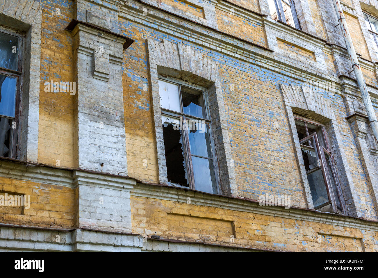 Fenêtres brisées dans un vieux bâtiment en brique abandonnés Banque D'Images
