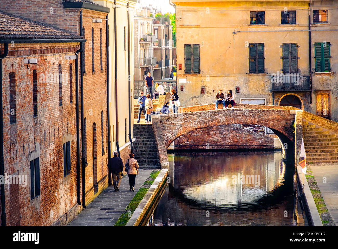 Escapade romantique en Italie, un son chaud de feux du coucher de soleil sur de vieux bâtiments en briques rouges et le pont sur le canal de Comacchio, Ferrare province Emilia Banque D'Images