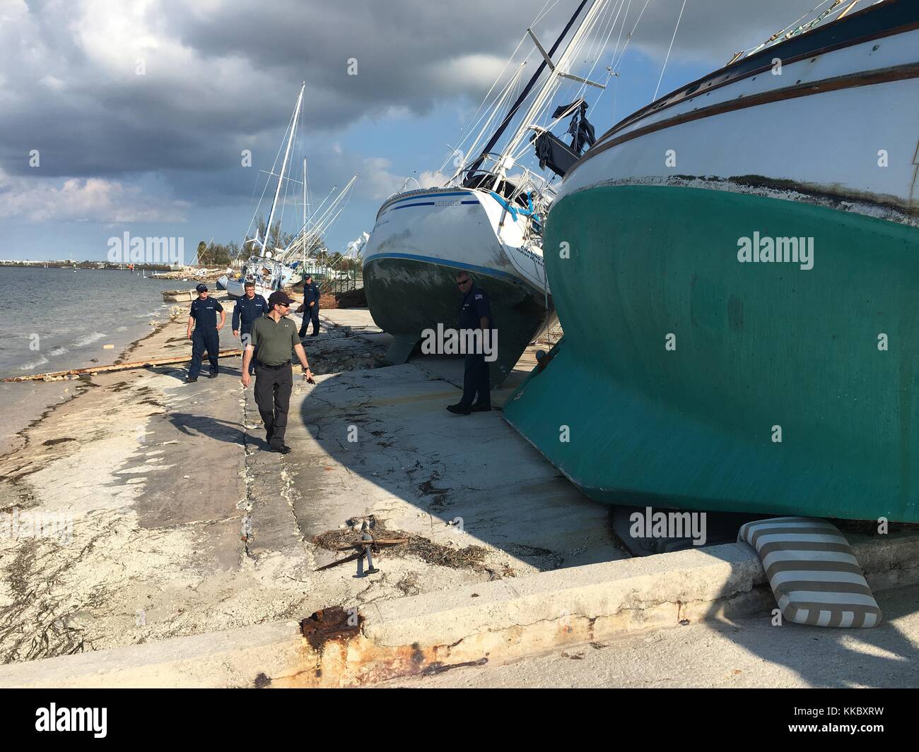 Des officiers de la Garde côtière américaine inspectent des voiliers endommagés débarqués à terre à la base aérienne navale Key West Trumbo point Annex lors des efforts de secours à la suite de l'ouragan Irma le 15 septembre 2017 à Key West, en Floride. (Photo de Christopher M. Yaw via Planetpix) Banque D'Images