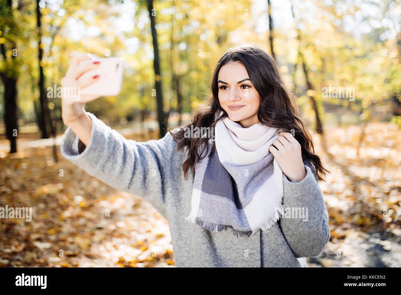 Jeune fille prend un fond de selfies sur le mur avec une belle d'automne les feuilles. Banque D'Images