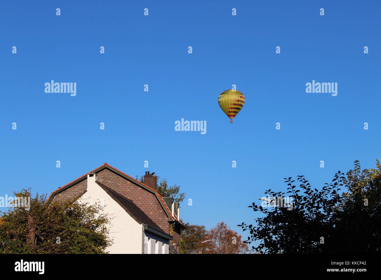 Vue d'une montgolfière multicolores voler au-dessus de la campagne néerlandaise. Banque D'Images