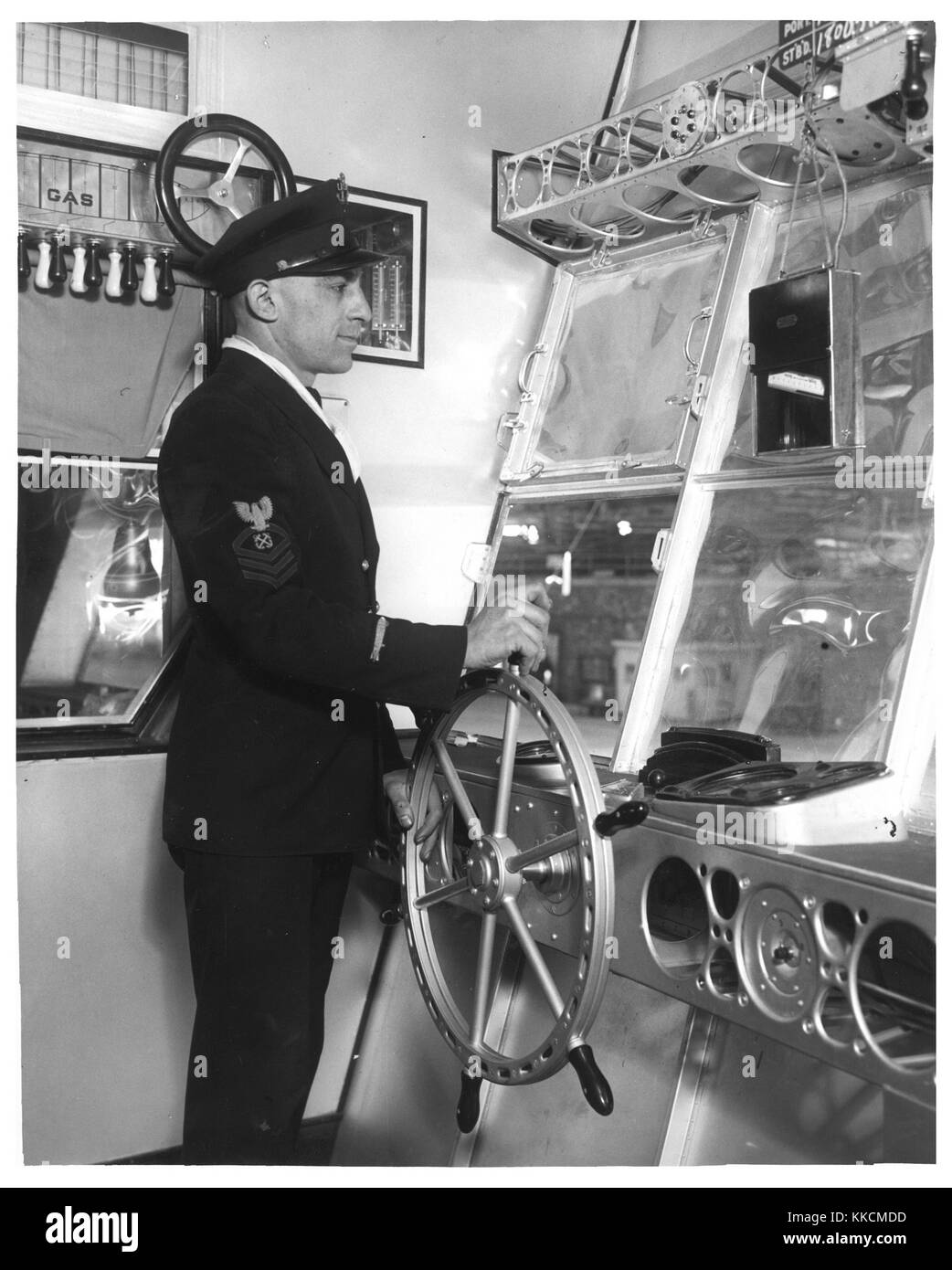 Photographie d'un membre de l'équipage utilisant une barre pour diriger un dirigeable. Image reproduite avec l'aimable autorisation des Archives nationales. 1933. Banque D'Images