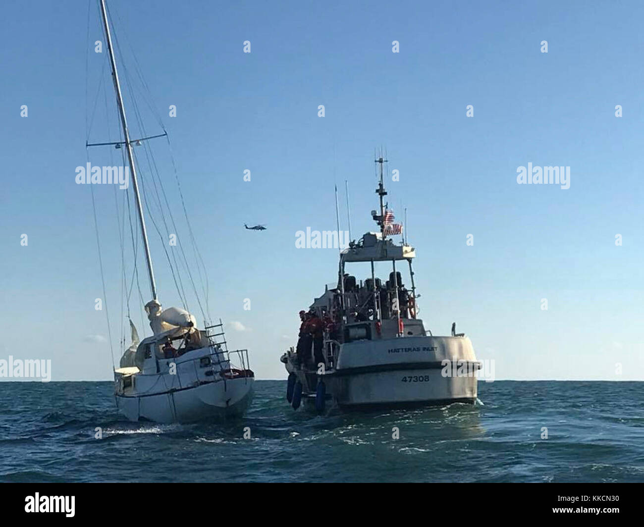 Un équipage de Motor Life Boat de 47 pieds de la Garde côtière de Station Hatteras Inlet s'approche d'un voilier qui prend l'eau à 13 milles à l'est de Hatteras Island, en Caroline du Nord, le 26 novembre 2017. Un équipage d'hélicoptère MH-60 Jayhawk de la station aérienne de la Garde côtière Elizabeth City et un équipage de bateau d'intervention de 29 pieds-petit de la station Hatteras Inlet sont également arrivés sur les lieux pour aider. (É.-U. Photo de la Garde côtière par Petty Officer 2e classe Chuck Seckinger/publié) Banque D'Images