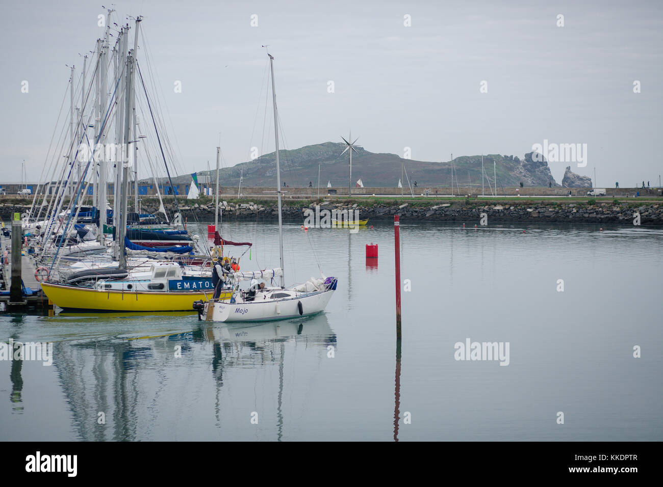 Homme naviguant dans son bateau hors du port de howth dans la mer d'Irlande, péninsule de Howth, Dublin, Irlande Banque D'Images