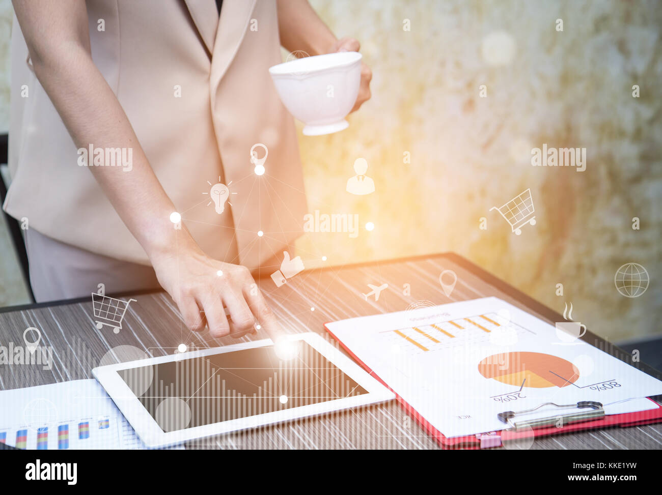 L'analyse des données et des concepts d'affaires importantes (BI) les femmes d'affaires tenant une tasse de café et des doigts tapant tablette avec icônes virtuels sur l'arrière-plan Banque D'Images