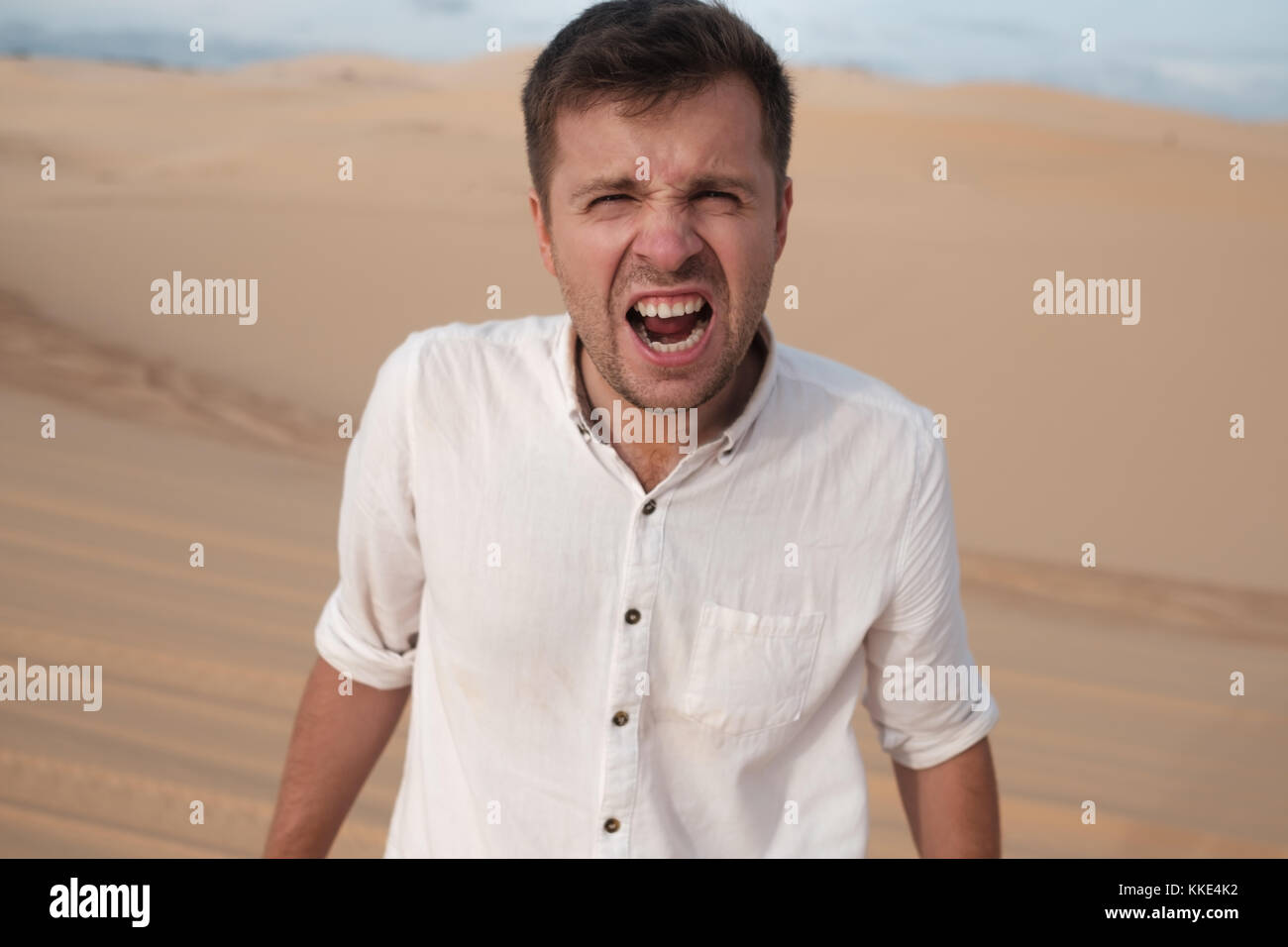 Homme en colère crier accusait quelqu'un standing in desert Banque D'Images