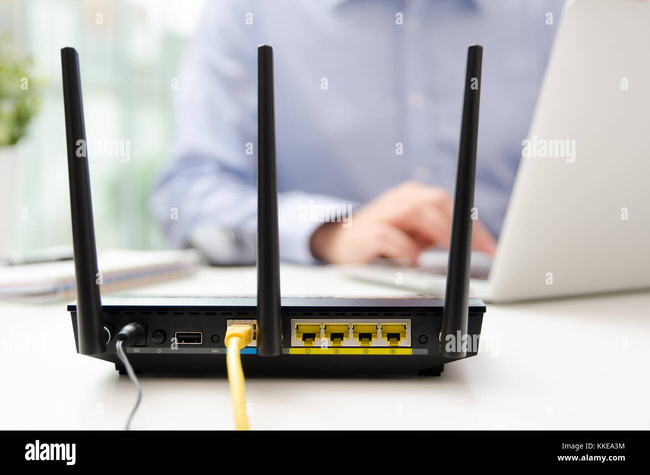 Routeur sans fil et l'homme à l'aide d'un laptop in office. Le routeur large bande sans fil wifi Téléphone portable accueil concept Banque D'Images