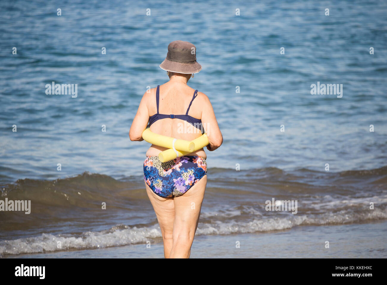 Les femmes espagnoles âgées qui vont nager dans la mer après leur cours de yoga/étirements quotidien sur la plage. Banque D'Images