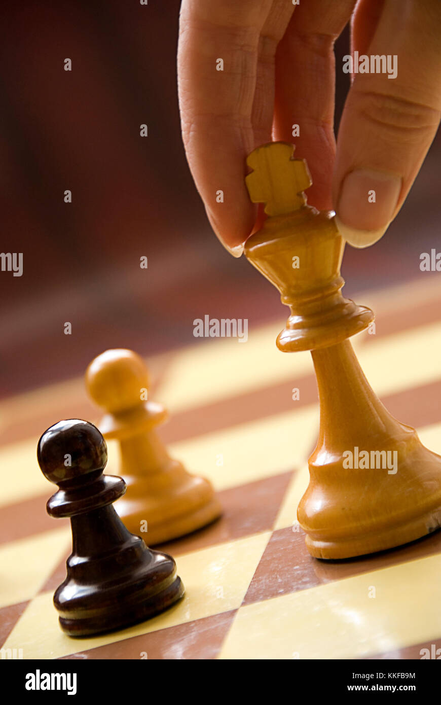 Une main de femme jouant aux échecs roi déplacer Banque D'Images