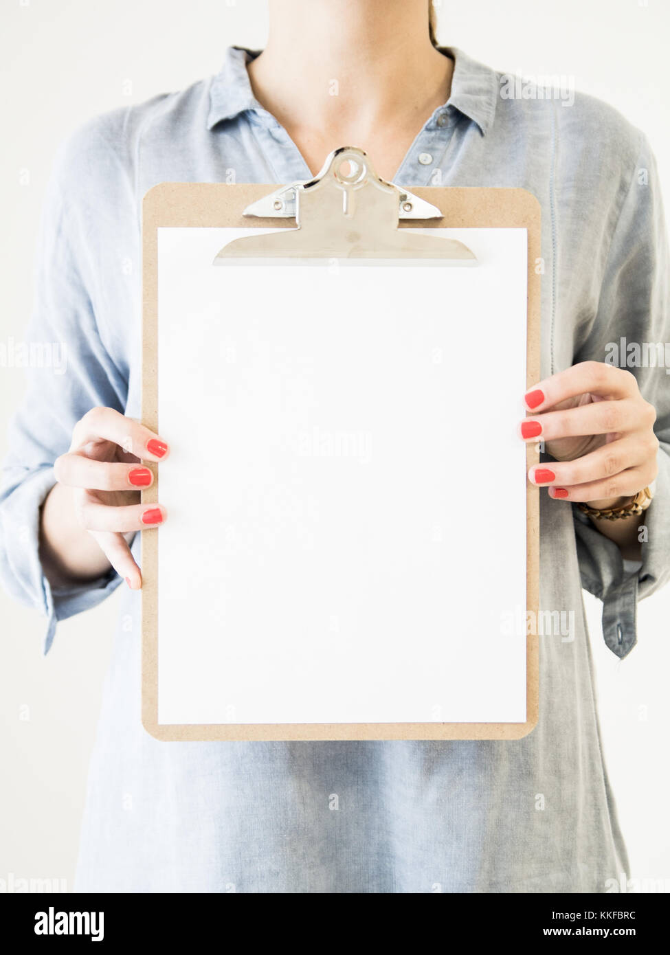 Femme caucasican montrant avec presse-papiers papier blanc vierge Banque D'Images