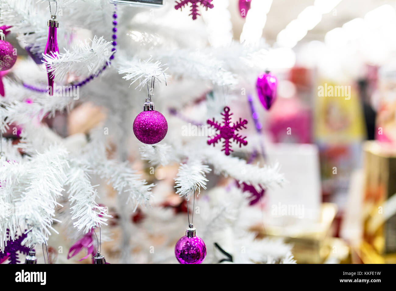 Boules rouges et décorations suspendu à un arbre de Noël blanc dans la vitrine d'un magasin du centre commercial au Royaume-Uni Banque D'Images