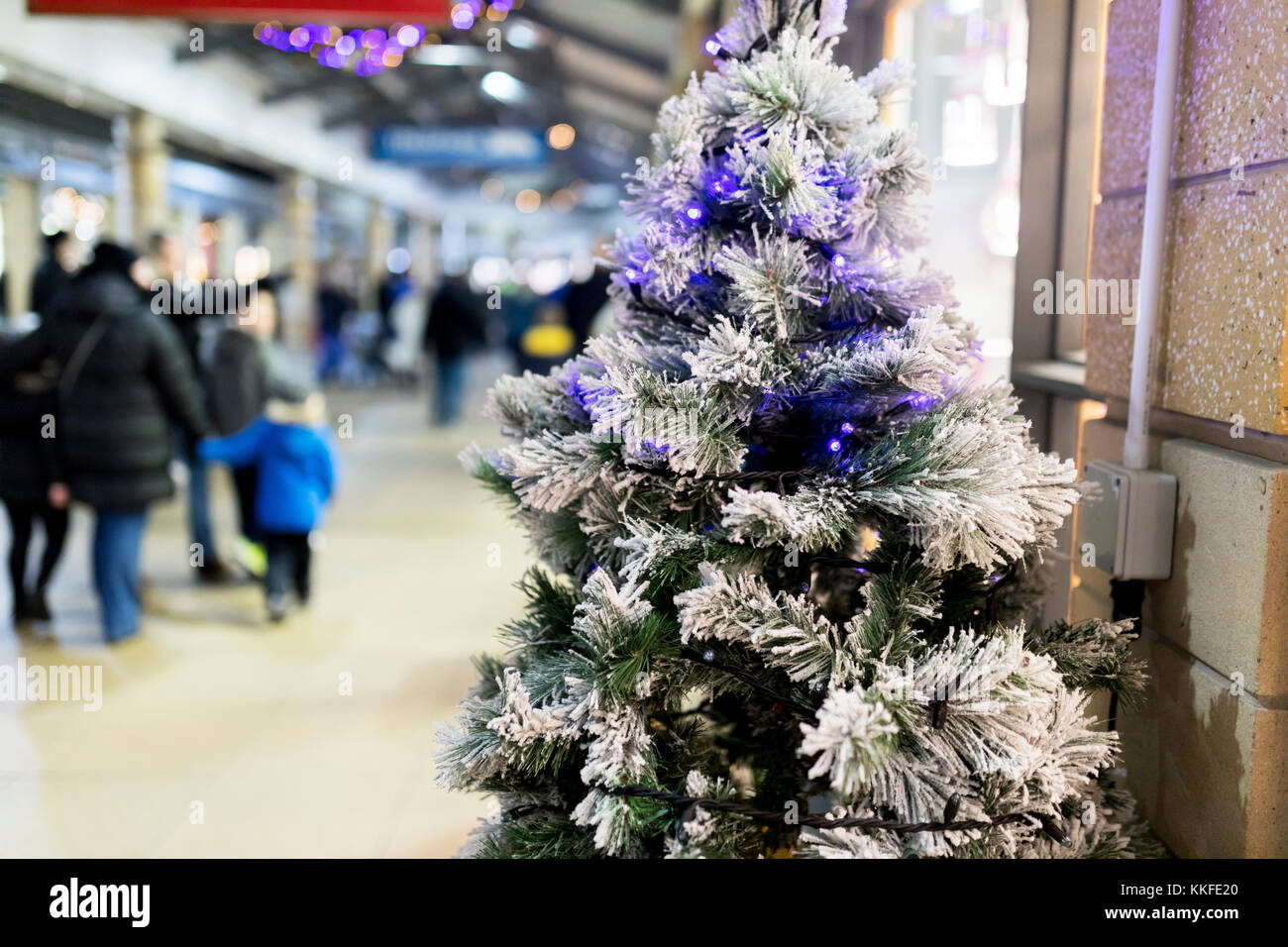 Près d'un arbre de Noël artificiel avec éclairage et de gel bleu clair de la neige ou dans un centre commercial ou un centre commercial avec des personnes floues dans la b Banque D'Images
