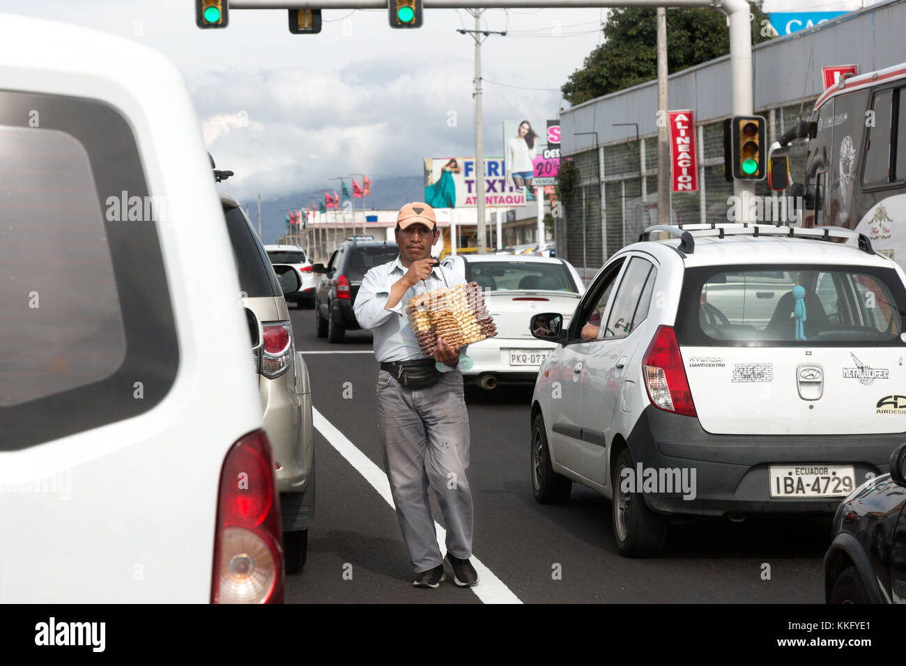 Équateur un homme qui vend des marchandises aux conducteurs de voitures s'est arrêté aux feux de signalisation, Équateur, Amérique du Sud Banque D'Images