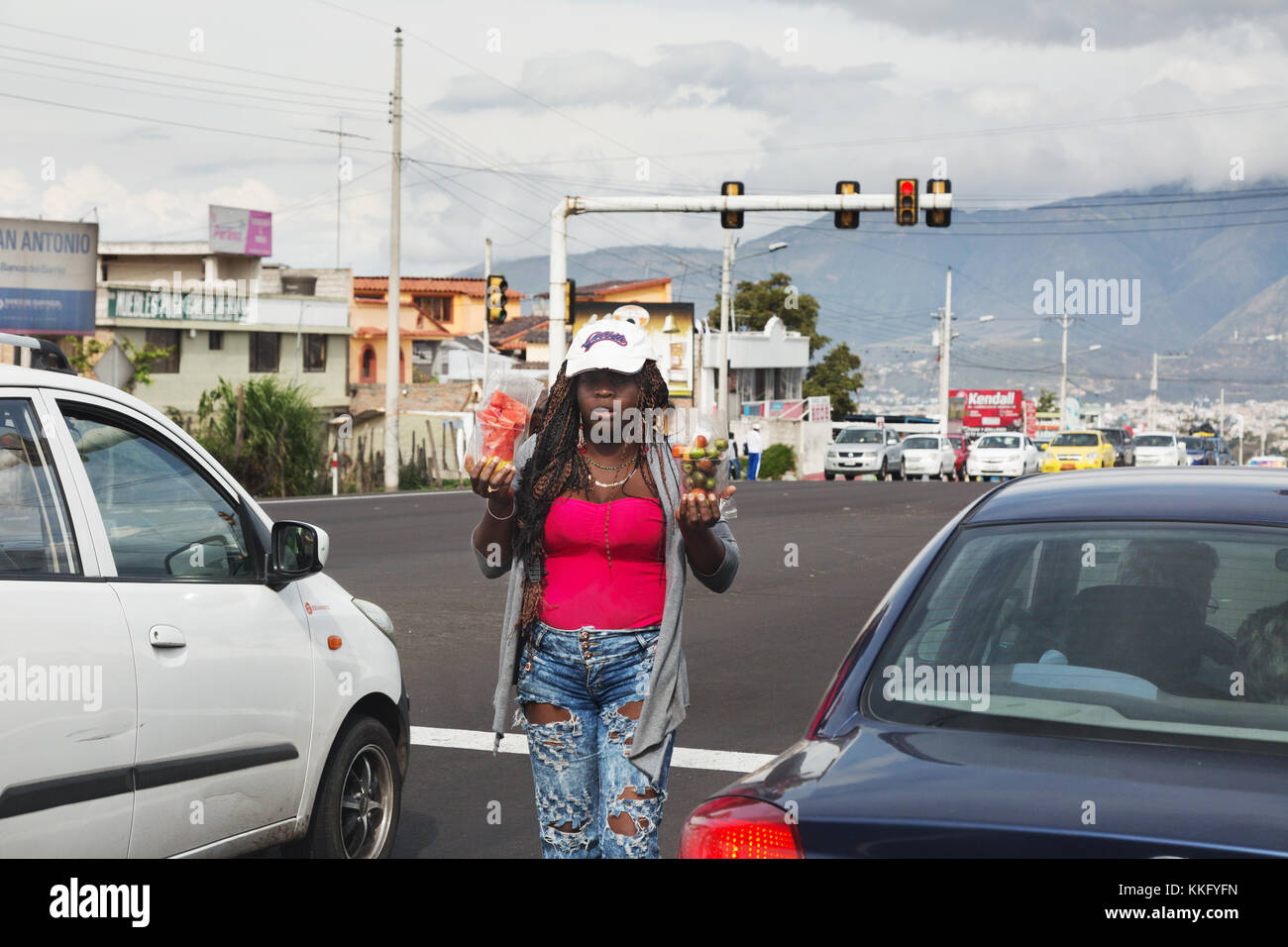 Une femme afro-équatorienne qui vend des marchandises aux conducteurs de voiture s'est arrêtée aux feux de signalisation, Équateur, Amérique du Sud Banque D'Images