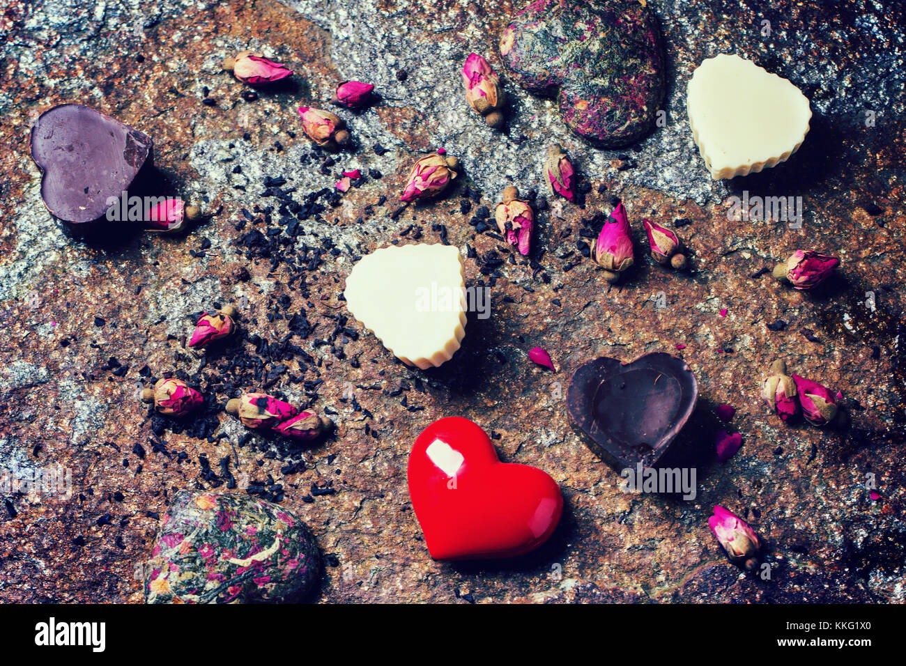 Bonbons de chocolat en forme de coeur avec des roses thé sec au fond de la pierre pour la Saint-Valentin avec effet filtre rétro. Banque D'Images