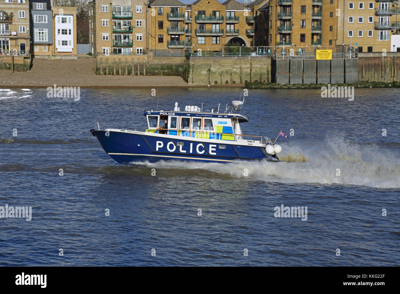 Un lancement de la police londonienne parcourt rapidement la Tamise. Montré en traversant Wapping, est de Londres, Royaume-Uni Banque D'Images