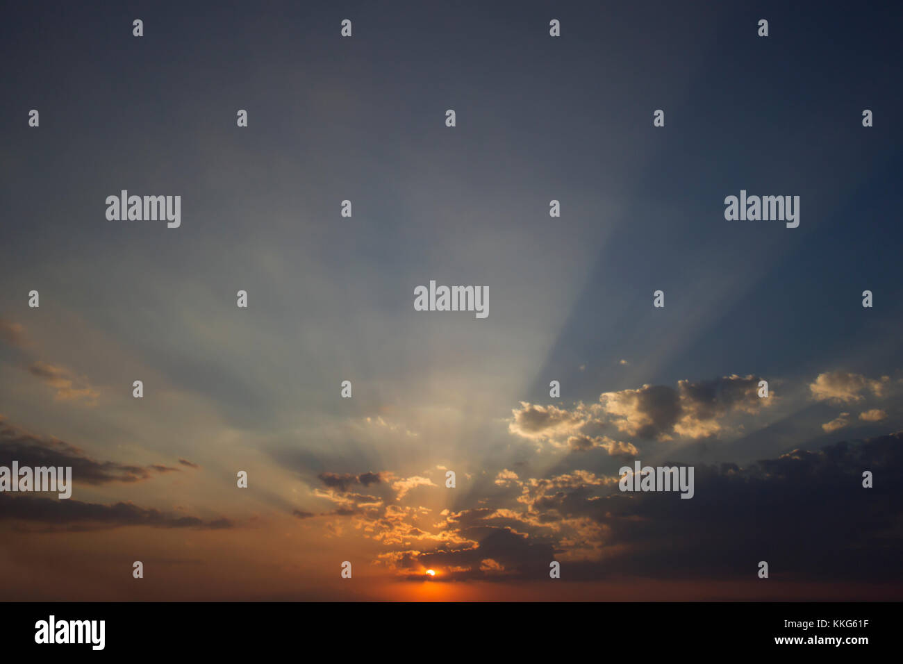 Photo horizontale d'un beau coucher de soleil nuages ciel riche en couleur et avec le soleil au centre de la photo Banque D'Images