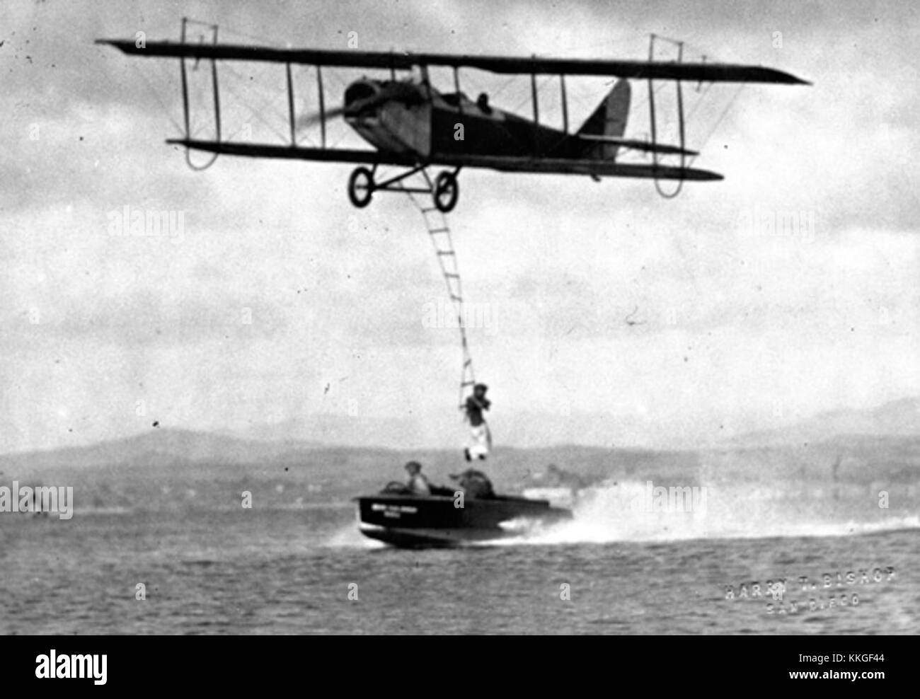Le JN-4, un biplan classique du début du XXe siècle, est représenté sur cette image avec un wingwalker effectuant des cascades sur ses ailes. Le JN-4, souvent associé à la première Guerre mondiale, est devenu célèbre pour son utilisation dans les spectacles aériens pendant la période d'après-guerre. Banque D'Images