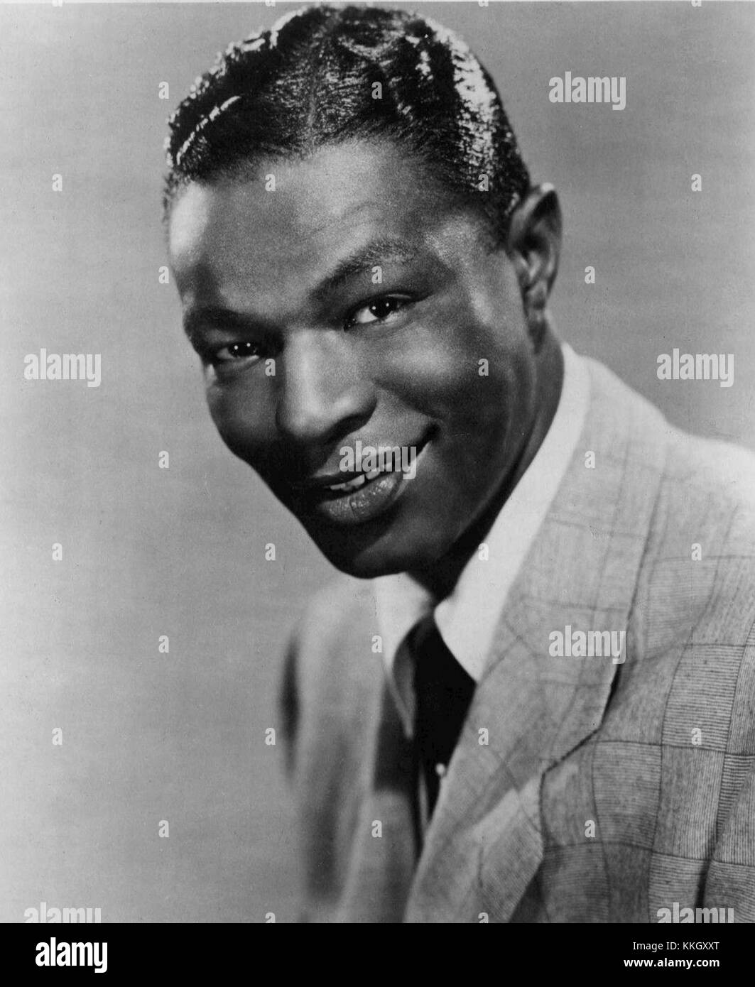 Cette photographie montre Nat King Cole, le légendaire chanteur et pianiste américain, prise en 1959. Connu pour sa voix douce et sa musique influencée par le jazz, Cole est l'une des figures les plus influentes de la musique du XXe siècle. Banque D'Images