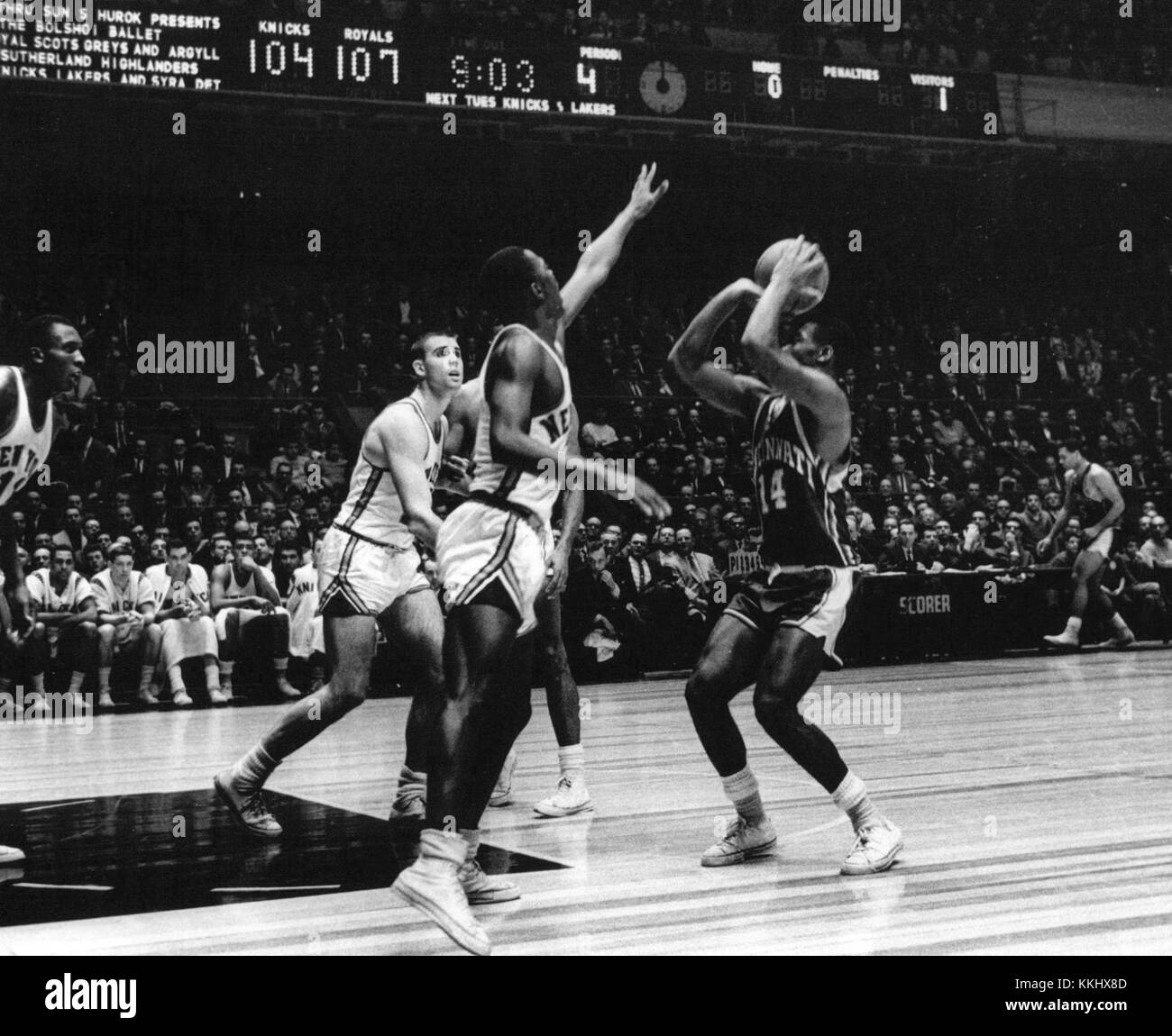 Cette image représente un match de basket-ball entre les Royals de Cincinnati, avec Oscar Robertson, et les Knicks de New York. Oscar Robertson, l'un des joueurs légendaires de la NBA, est connu pour ses compétences et sa domination dans le jeu. Ce match met en lumière sa carrière dans les années 1960 et son impact sur le sport. Banque D'Images