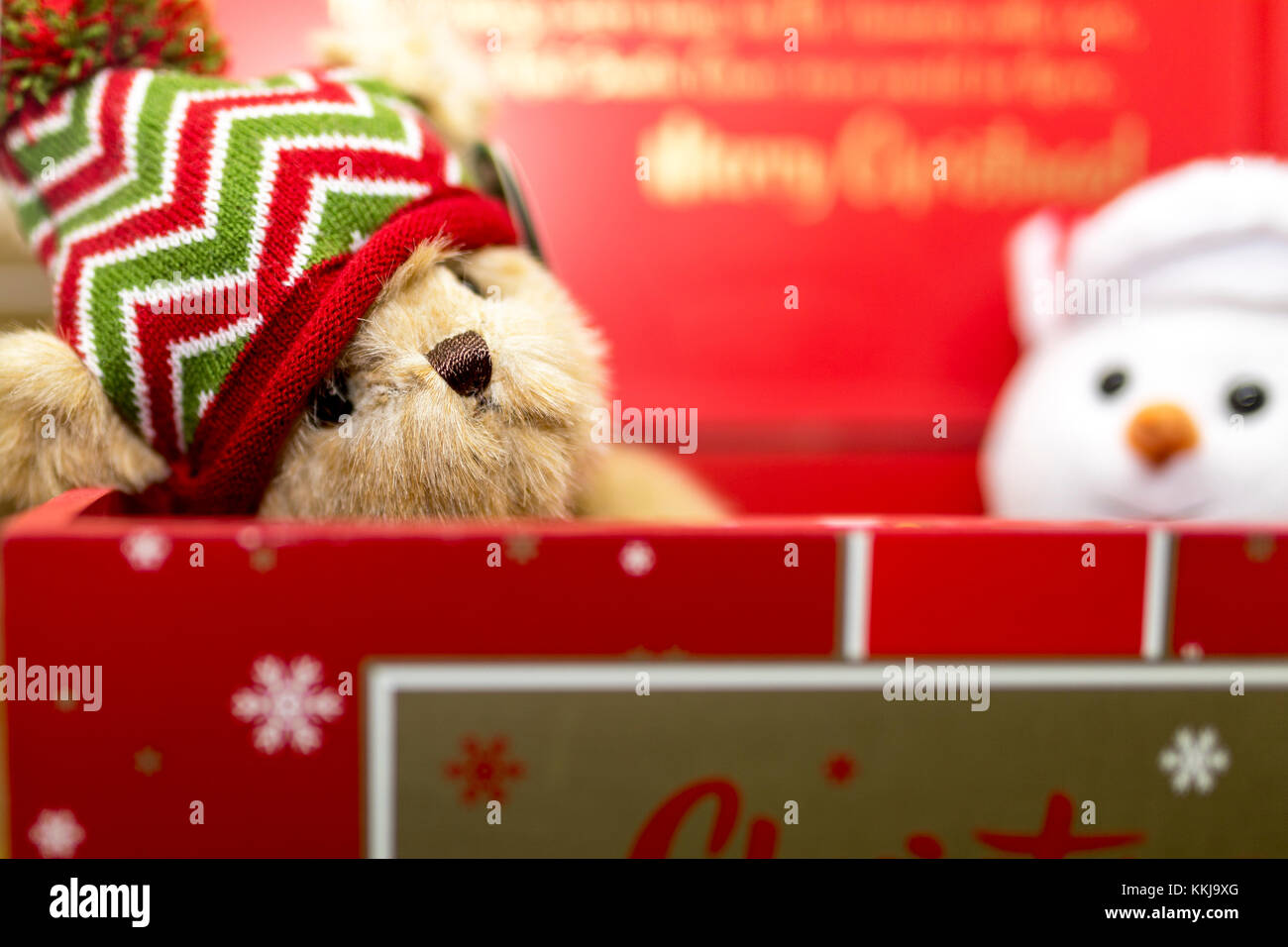 Vintage brown fête ours portant un chapeau laineux dans une boîte-cadeau de Noël rouge avec un bonhomme adorable en peluche Banque D'Images