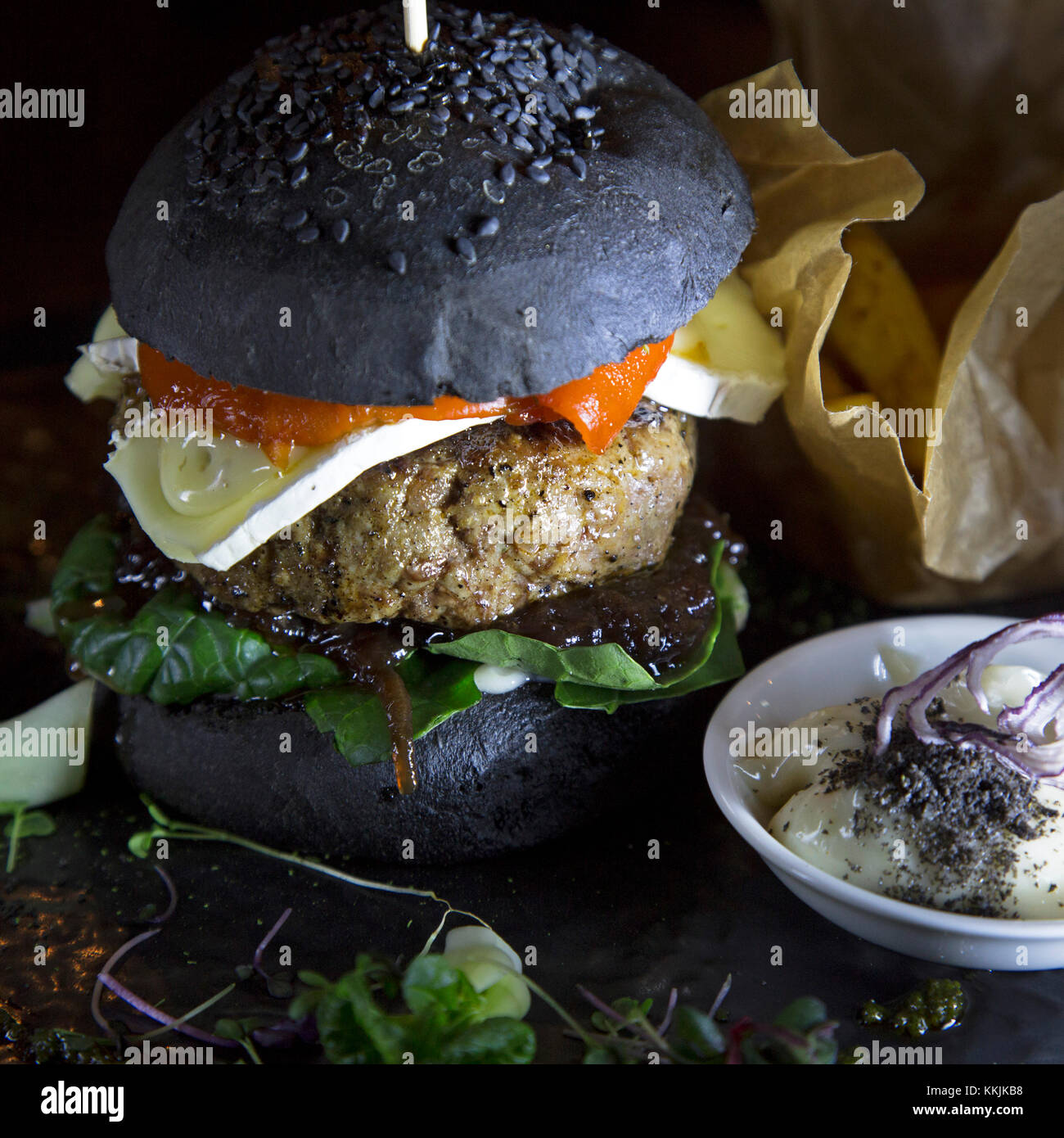 Hamburger d'agneau servi avec pain noir dans un bun au restaurant sourdine à Riga, Lettonie. Le burger dispose d'une tranche de fromage français. Banque D'Images