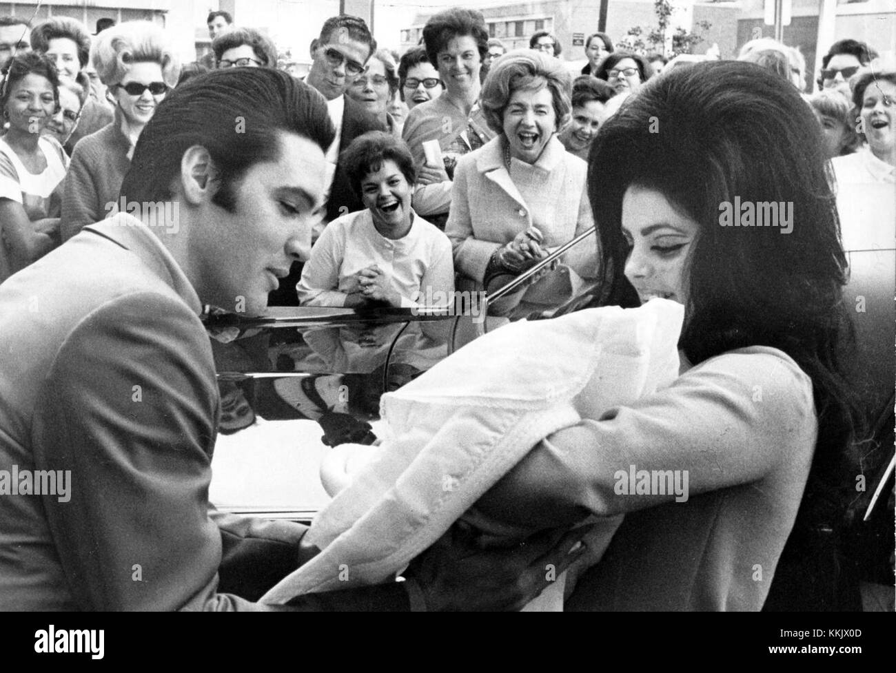 Cette célèbre photographie de février 1968 montre Elvis Presley, sa femme Priscilla et leur fille Lisa Marie Presley. La famille est capturée pendant une période d’attention publique dans leur vie personnelle, marquant un moment important dans l’histoire de Presley familyâ€™. Banque D'Images