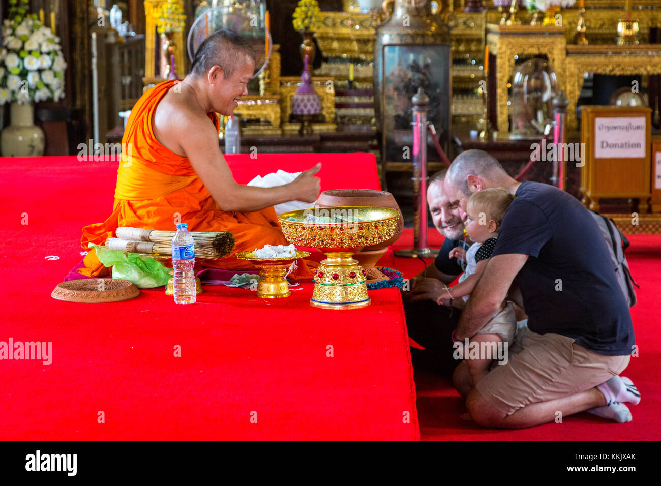 Bangkok, Thaïlande. Un père présente son fils pour une bénédiction par un moine bouddhiste à l'Ubosot du Wat Arun Temple. Banque D'Images