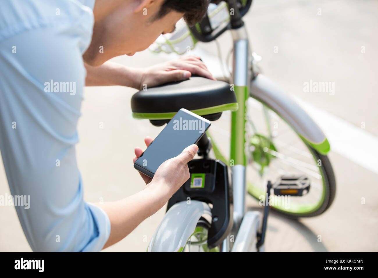 Les jeunes Chinois de la numérisation d'un QR code pour débloquer un vélo partager Banque D'Images