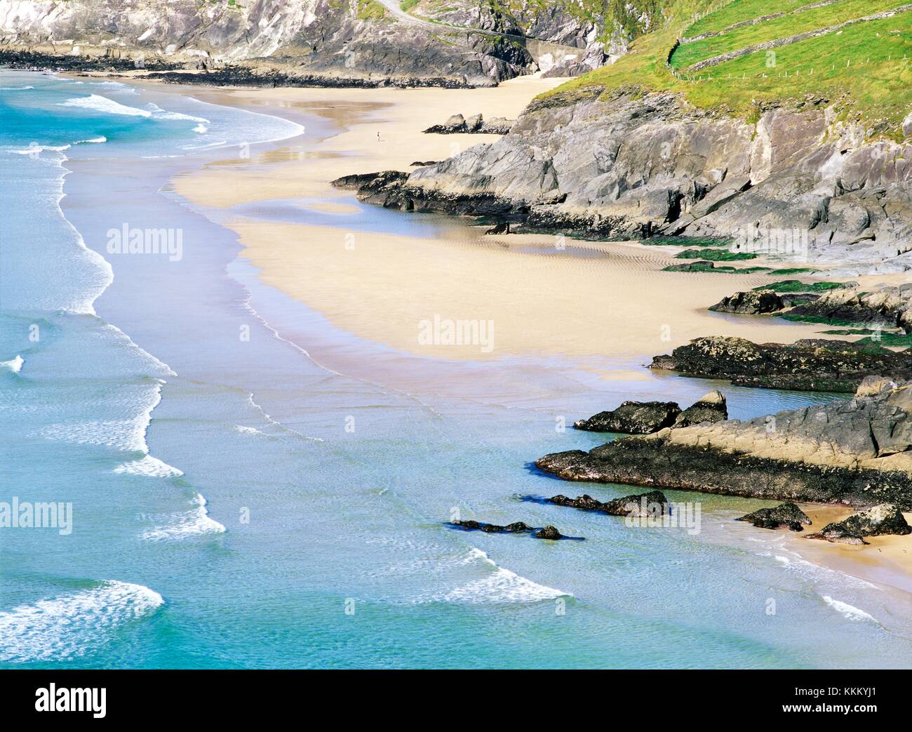 La plage en dessous de Slea Head à l'ouest de Ventry et Dingle sur la péninsule de Dingle dans le comté de Kerry, en Irlande. Figure marchant sur le sable Banque D'Images