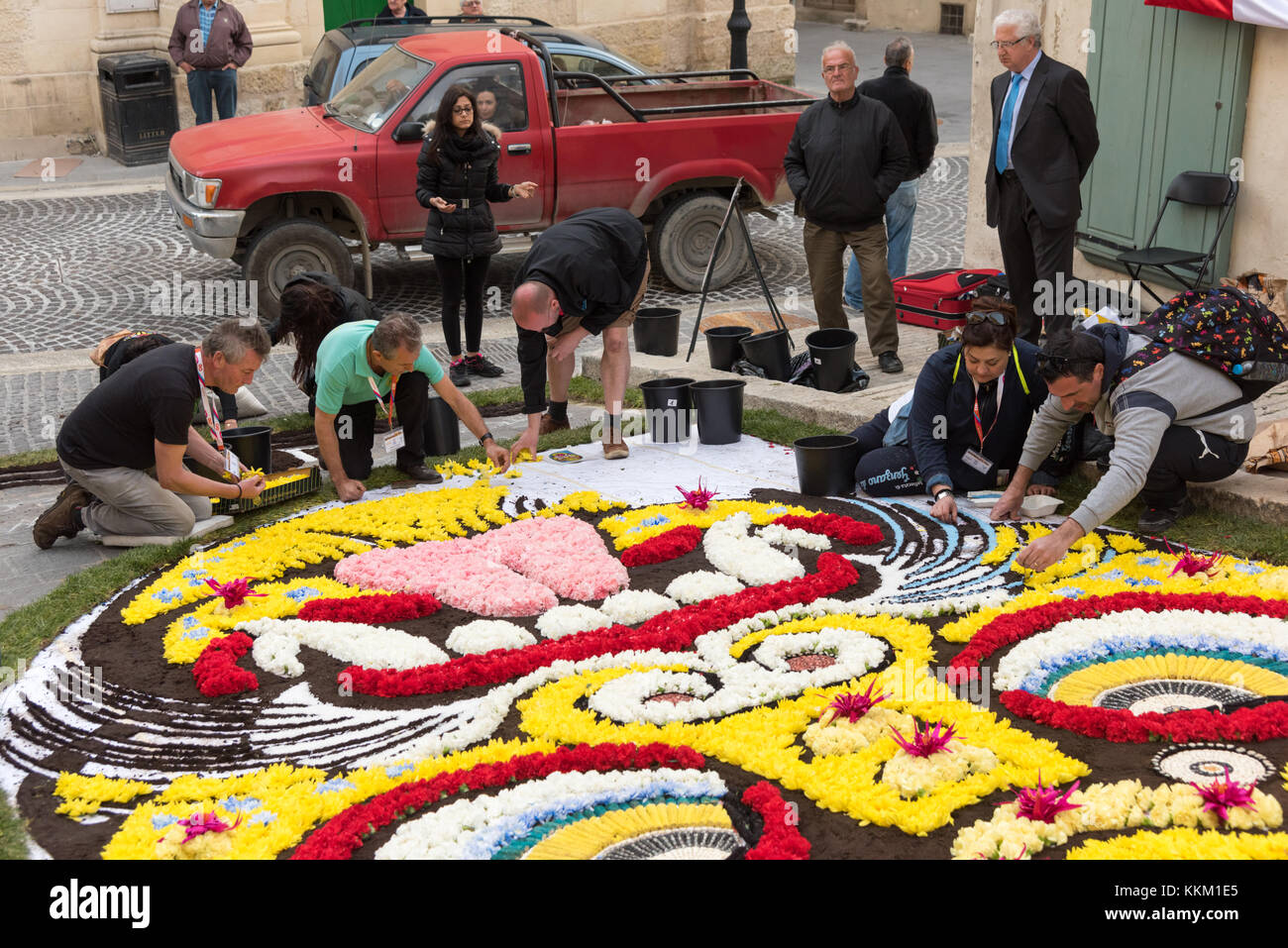 Les gens qui artistict les décorations de la rue à l'aide de pétales de fleurs dans un festival à l'île de Gozo, à Malte Banque D'Images