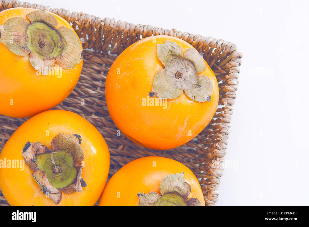 Fraîches et naturelles dans le panier de fruits kaki sur fond blanc Banque D'Images