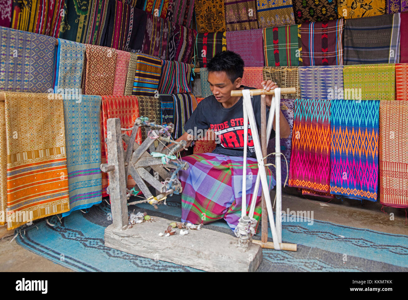 Tisserand indonésien tissage de tissus traditionnels de chants sur des métiers en bois primitifs dans le village de Sasak Sade sur l'île de Lombok, Indonésie Banque D'Images