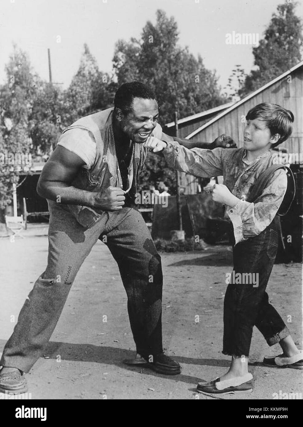En 1960, Archie Moore, un ancien champion du monde de boxe, a été présenté aux côtés d'Eddie Hodges, un enfant acteur et chanteur. Moore, connu pour sa longue carrière et son succès dans la division des poids lourds légers, et Hodges, reconnu pour sa carrière d'acteur et de musique, représentaient deux facettes distinctes de la culture pop américaine dans les années 1960 Le jumelage met en évidence le croisement entre le sport et le divertissement pendant cette période. Banque D'Images