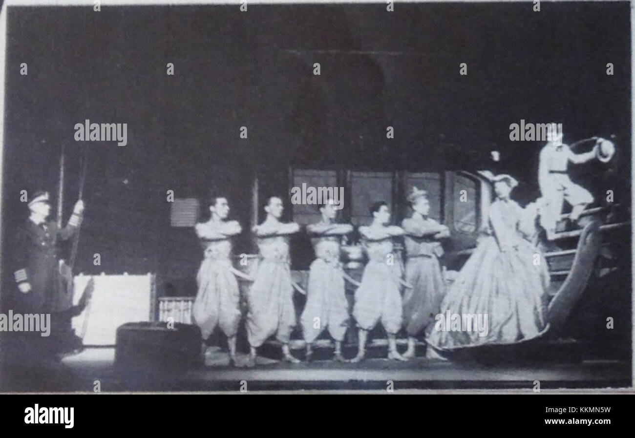 La comédie musicale « le Roi et moi » présente une scène où les personnages débarquent d'un bateau, ouvrant la voie à l'échange culturel dans l'histoire. La production présente des thèmes de conflit culturel et de croissance personnelle dans un cadre royal. Banque D'Images