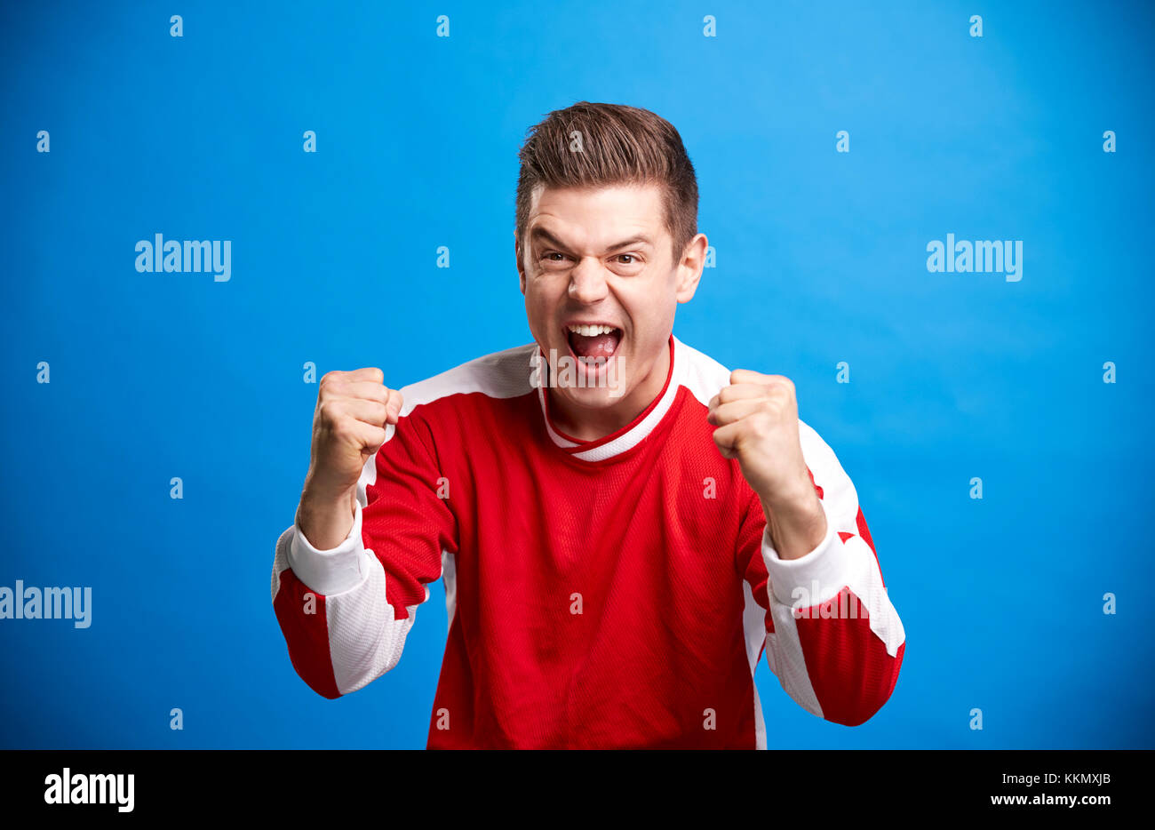 Un jeune homme de race blanche sports fan acclamations et célébrer Banque D'Images