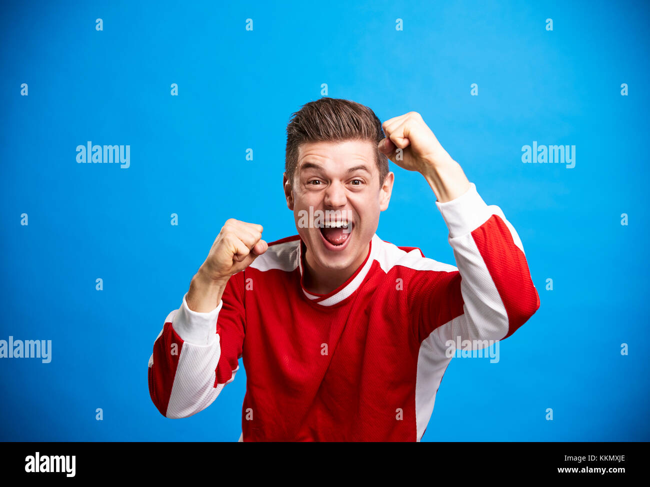 Un jeune homme de race blanche sports fan acclamations et célébrer Banque D'Images