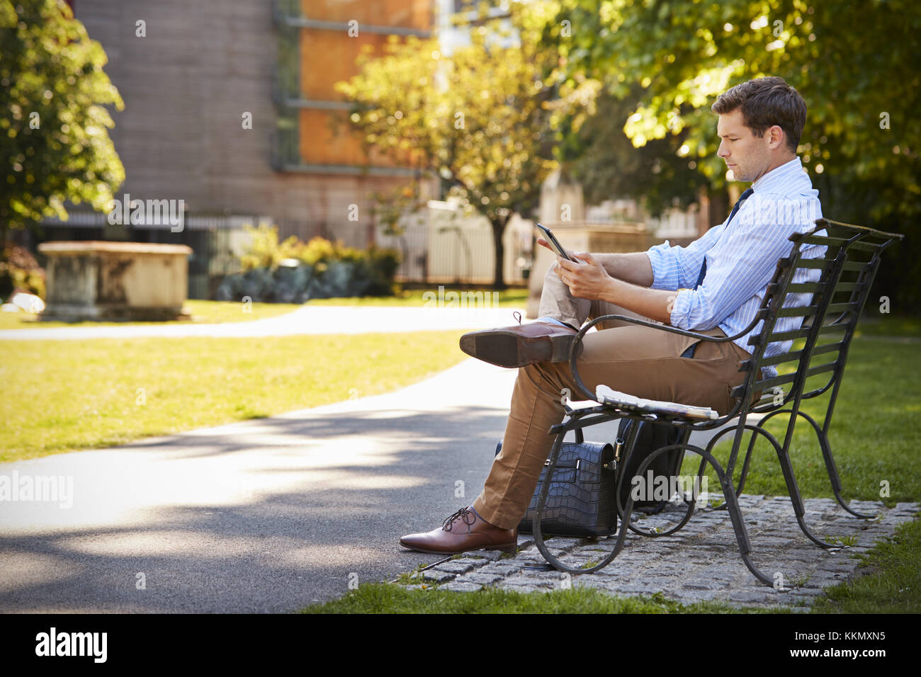 Businessman Outdoors Using Digital Tablet On Pause déjeuner dans le parc Banque D'Images