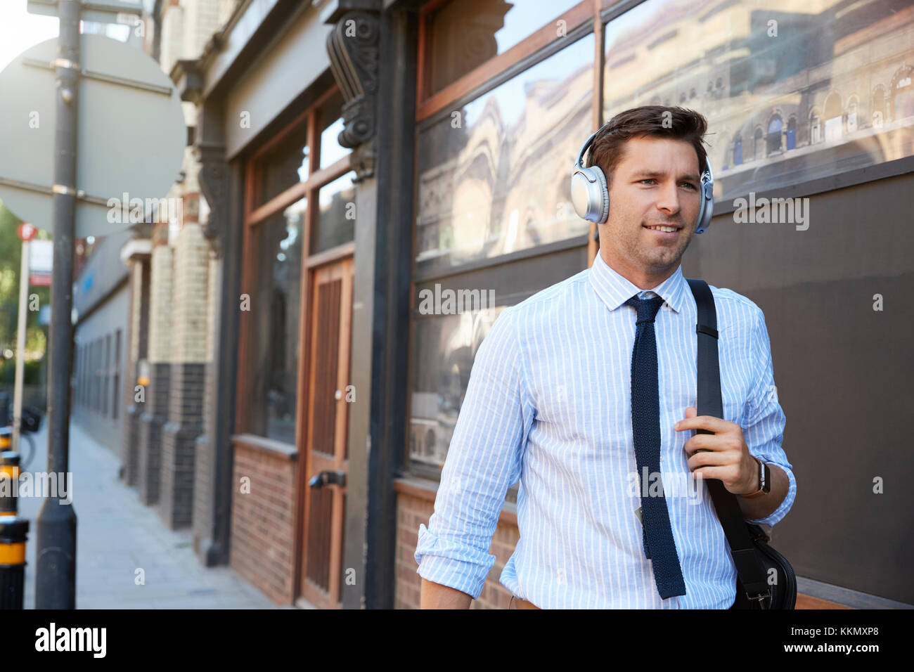 Businessman Wearing des écouteurs sans fil au travail à pied Banque D'Images