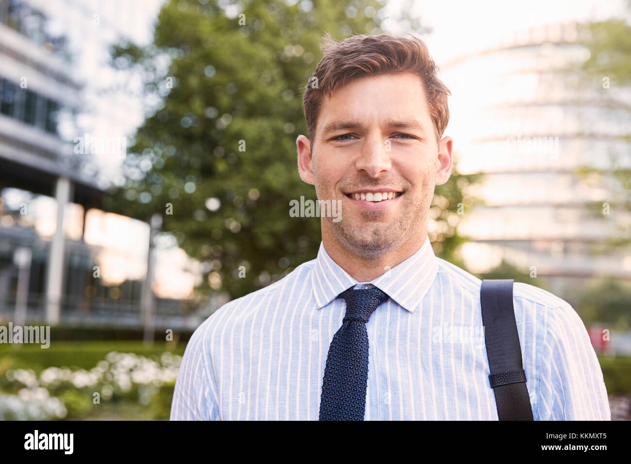 Portrait Of Businessman Walking Through City sur chemin du travail Banque D'Images