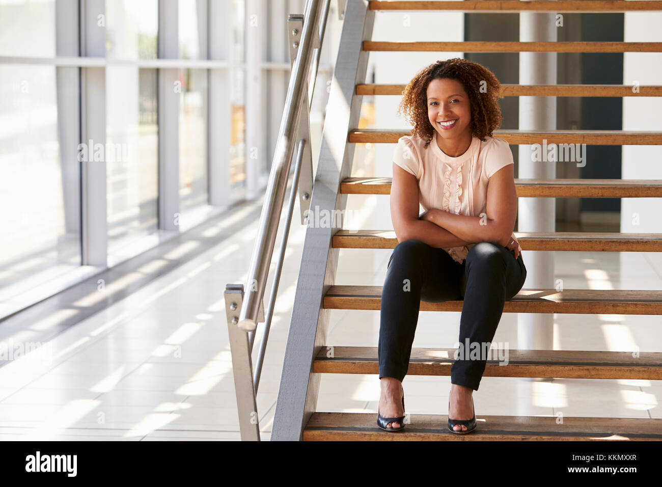 Portrait of a smiling woman sitting on stairs Banque D'Images