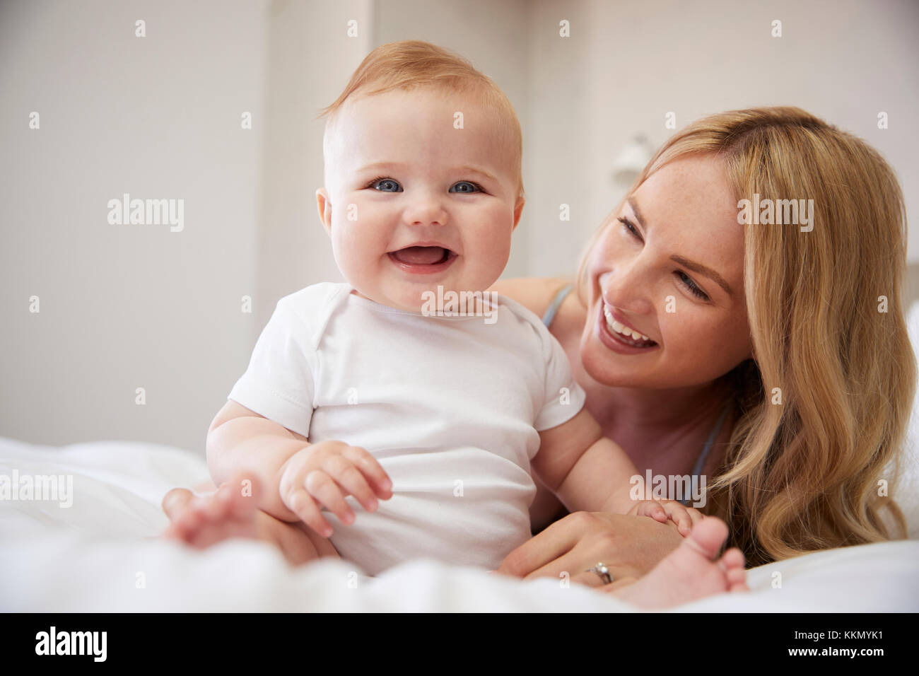 Mother Lying On Bed At Home With Baby Son Banque D'Images