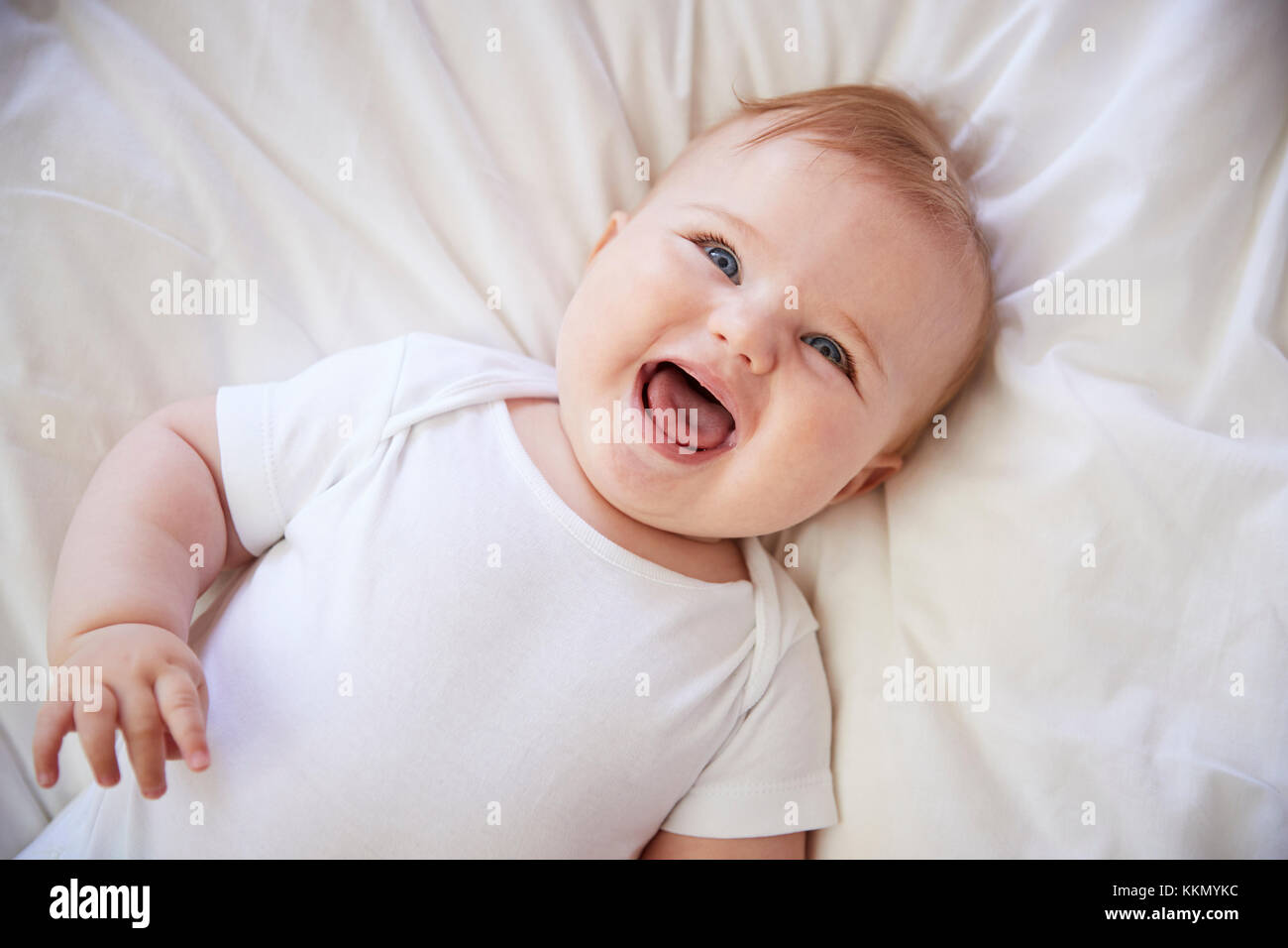 Coup de frais généraux de Happy Baby garçon couché sur le lit des parents Banque D'Images