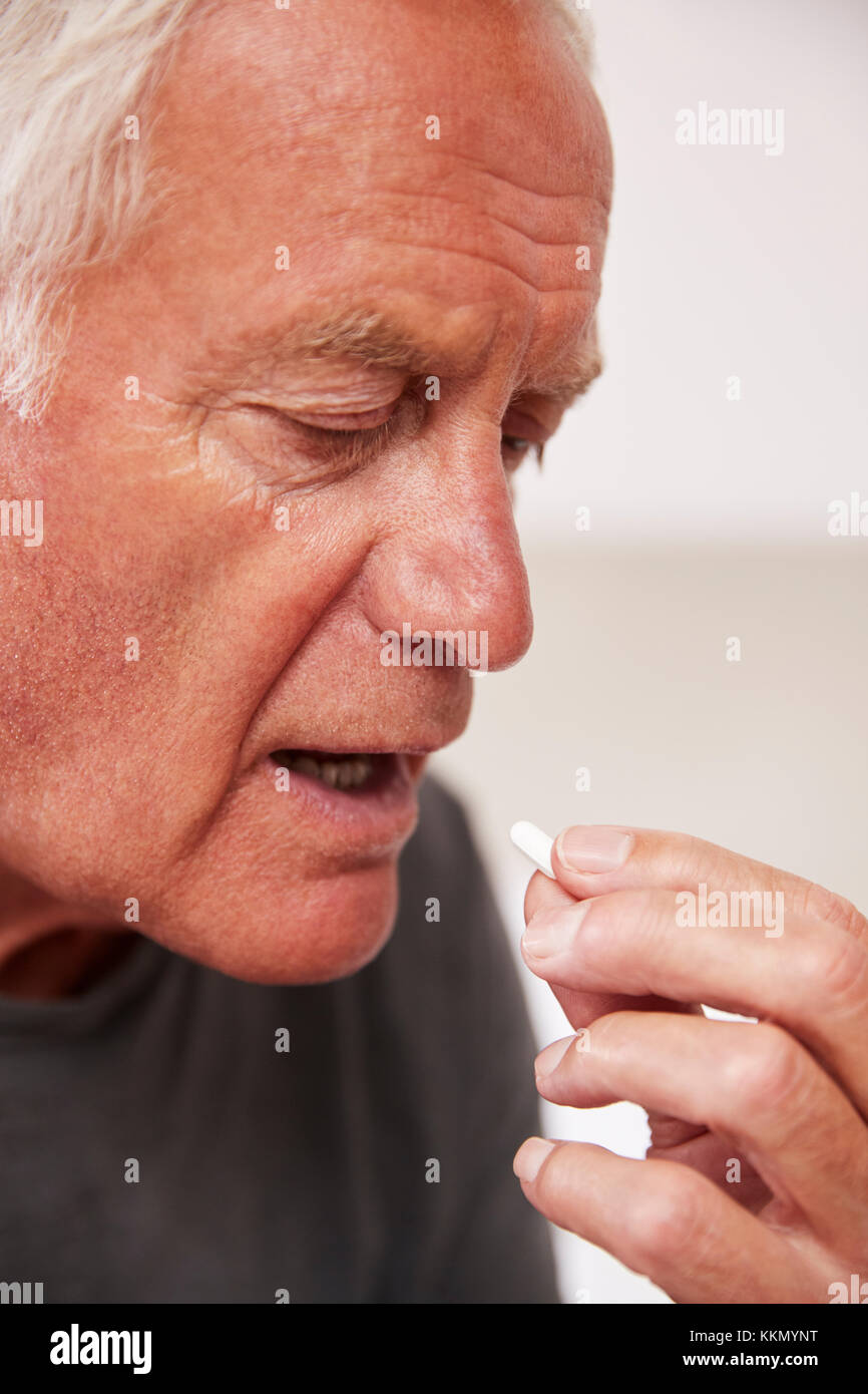 Senior Man Sitting on Bed At Home Prendre des médicaments Banque D'Images