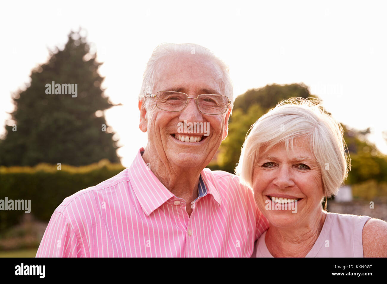 Senior couple in jardin souriant pour appareil photo, Close up Banque D'Images