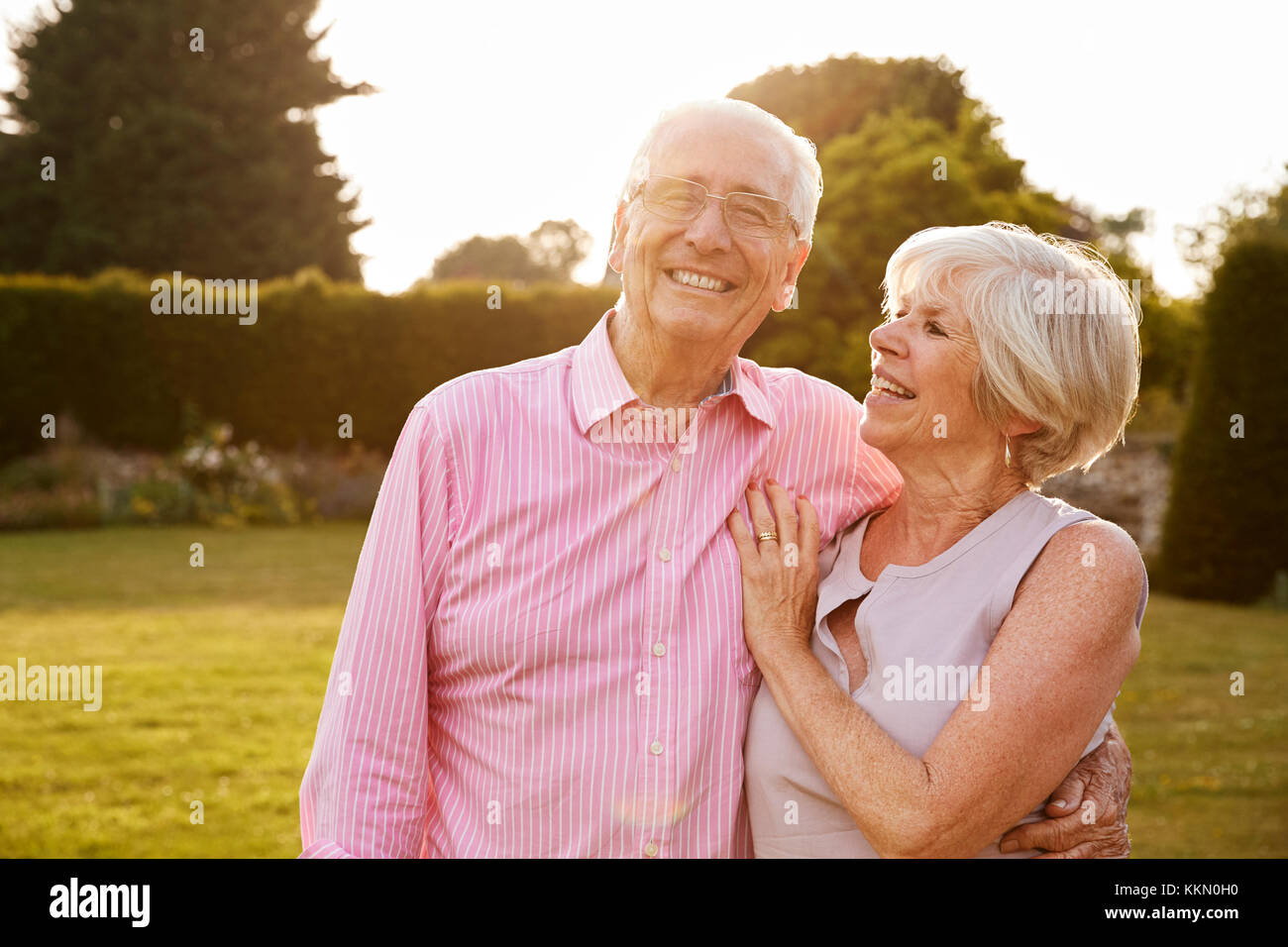 Senior couple in jardin souriant pour appareil photo, Close up Banque D'Images